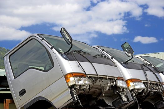 Image of half cut trucks at a junkyard.