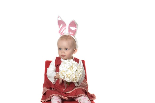 Closeup portrait of little girl with hare ears sitting on the chair