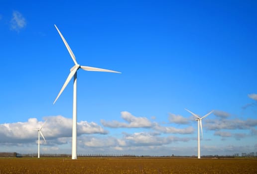 Wind Turbines in the field with blue cloudy sky