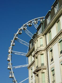 White wheel roundabout behind old building by beautiful weather