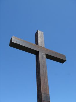 Brown wood cross and deep blue sky