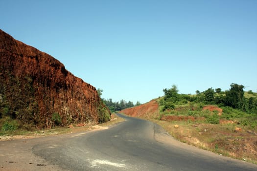 A view of a winding road in the Indian tropical countryside.