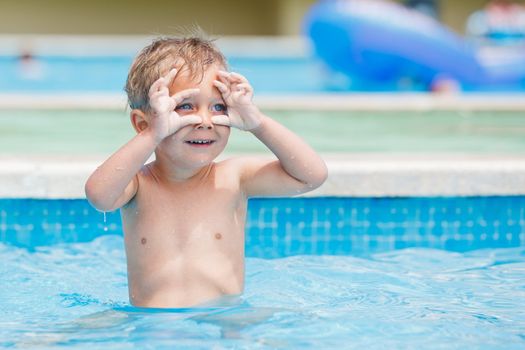 boy playing in a pool of water during the summer