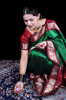 An Indian woman decorating her house with traditional candles on the occasion of Diwali festival.