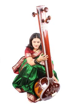 A female Indian classical singer smiling beautifully, on white studio background.