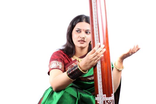 An Indian classical music singer in performance with the instrument called Tanpura.