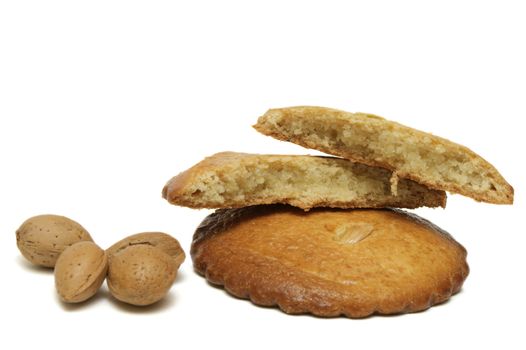 two filled almond cakes with some almonds