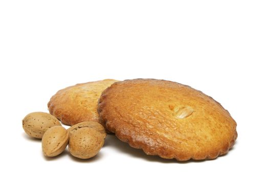 two filled almond cakes with some almonds