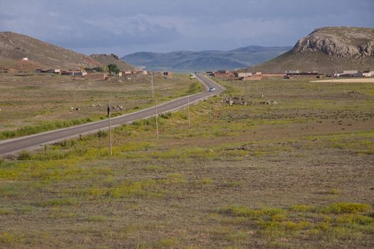 Route from Dogubayazit to Van. Sunset in background mountain. Green meadow dark clouds on the sky