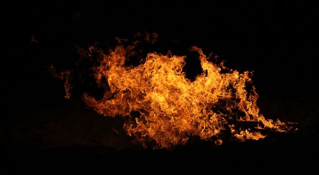 A raging bonfire burns on the beach.
