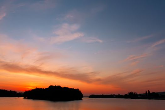 Multicolour cloudscape over reservoir at sunset, fine summer evening. Khmelnitsky, Ukraine