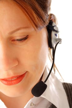 Cropped image of a yound attractive business woman with headset looking down and smiling, isolated over white background