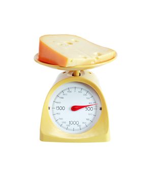 Piece of cheese lying on nice yellow kitchen scale. Isolated on white with clipping path