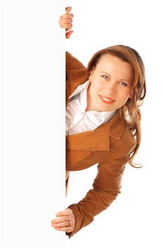 Portrait of a young attractive smiling business woman holding a big poster on one side, isolated over white background