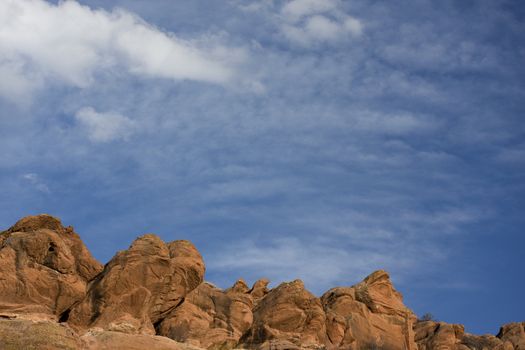 red sandstone rocks, blue sky with delicate white cumulus and cirrocumulus clouds at foothills of Rocky Mountains in Colorado