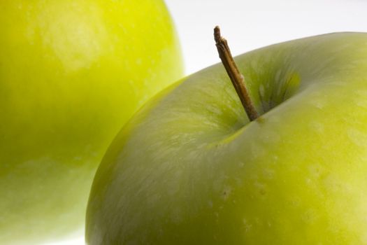 macro of two green Granny Smith apples on white background, selective focus