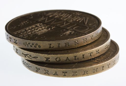 liberty, equality, fraternity words engraved on edge of old French coins, 10 Francs, 1977 (liberte, egalite, fraternite), white background