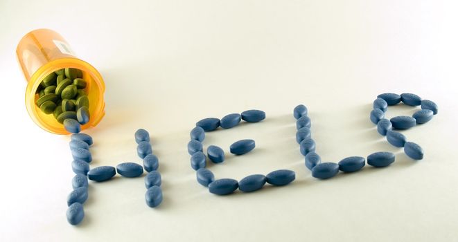Big blue pills spell the word help.