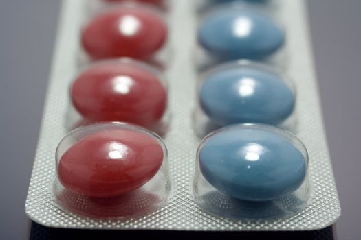 red and blue pills in packing, focused on first pills