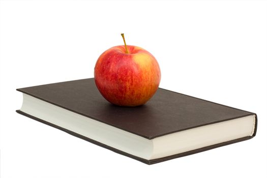red apple on a black book, isolated over white background