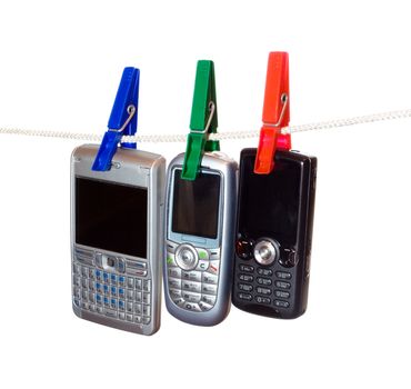 Three mobile phones on a clothes line, hanging with clothes-peg