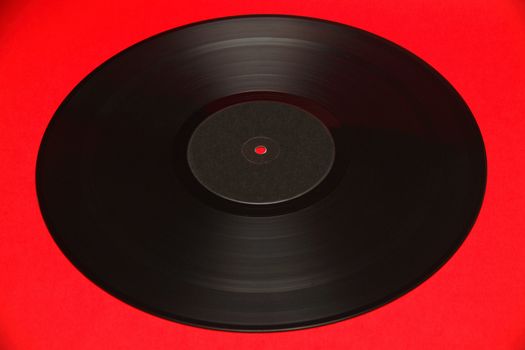 A gramophone record isolated on a red background.