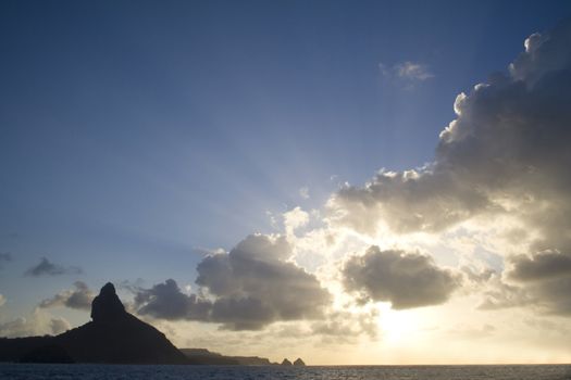 Rays of light on a late evening behing the "Peak Hill" and the "Two Brothers Hill" in Fernando de Noronha, Brazil.