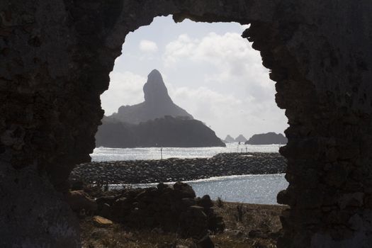 A view from inside what looks like a cave, of the ocean and islands in the background.