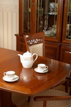 Two cups and  teapot on a table