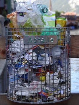 Overstuffed trashcan filled up until the top