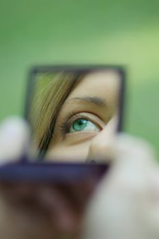 Female eye reflected in a mirror, removed in a sunny day