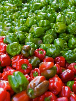 Red and green peppers in a big pile at the farmers market