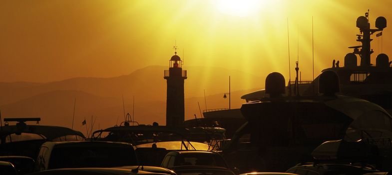 Lighthouse of saint tropez with ships in sunset