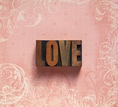 the word 'love' on a pale pink background with decorative swirls
