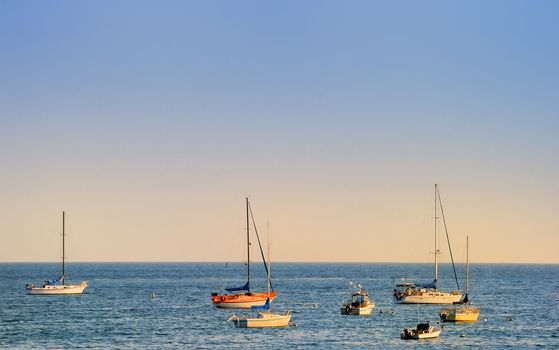 Several boats at the sea on a sunny late afternoon.