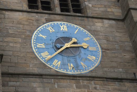 A Blue and Gold Clock on the Tower of an English Cathedral