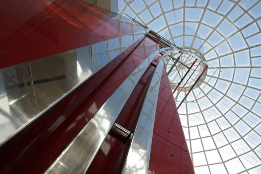 Huge hall of modern shopping centre with the glass lift and a transparent glass dome