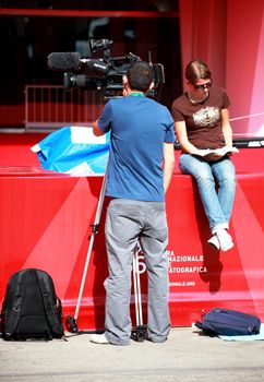 Journalists waiting for actors and directors on red carpet.