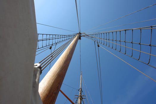 Foresail, Jib, and Wooden Mast of a sailing yacht vertical perspective boating background
