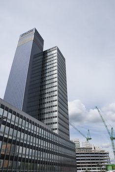 Two Skyscraper Blocks with Construction Cranes in the Background