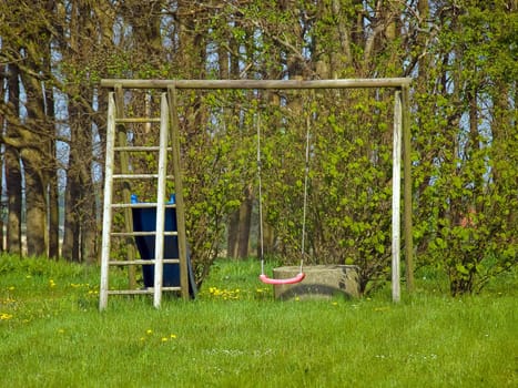 Red garden swing in a small outdoors garden