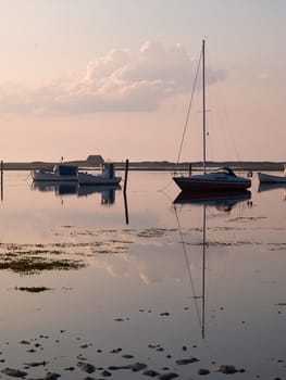 Magical sunset with boats reflection in the sea perfect sailing boating vertical image