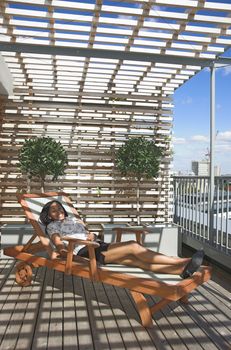 Beautiful mixed race woman enjoying a beautiful day on her apartment balcony. 