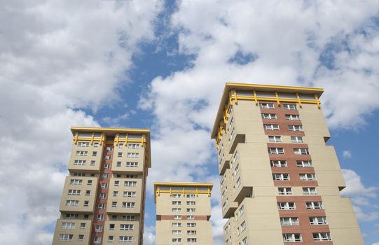 Yellow Cream and Brown Public Housing Apartment Block under a summer sky