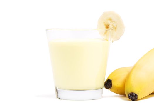 banana milkshake with a piece of banana and bananas aside on white background