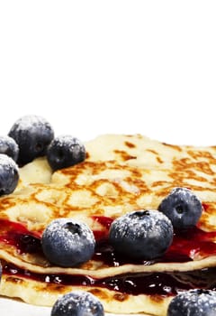 sugar covered blueberries on pancakes with jam on white background