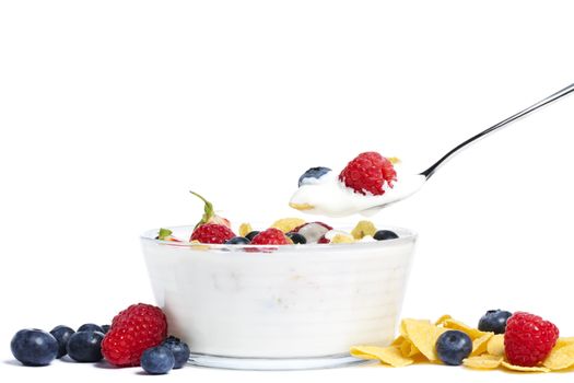 yogurt with blueberries, strawberries, raspberries and cornflakes on white background