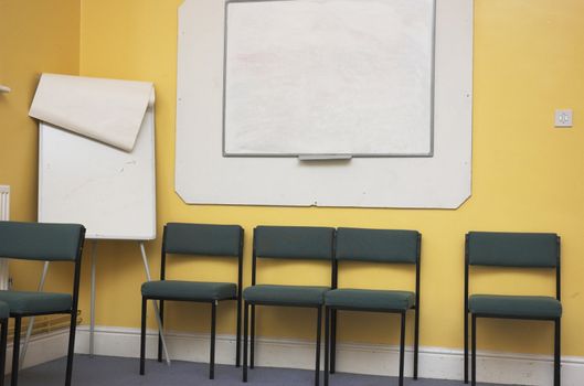 Empty classroom / meeting room with whiteboard and flipchart.