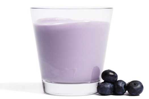 some blueberries near a milkshake on white background