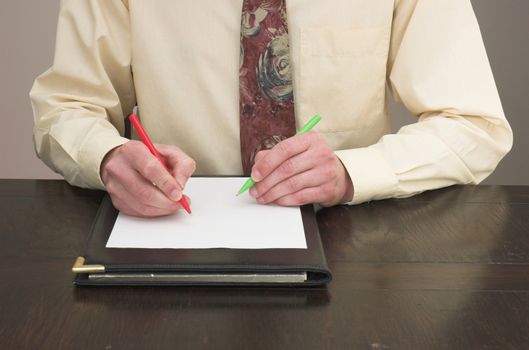 Man working at desk with pens in both hands!